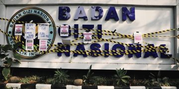 MBG Watch memasang garis kuning-hitam atau menyegel secara simbolis area depan kantor BGN
